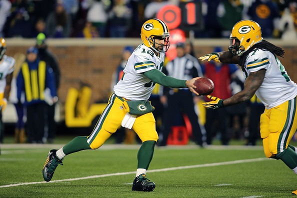 Aaron Rodgers #12 hands off the ball to Eddie Lacy #27