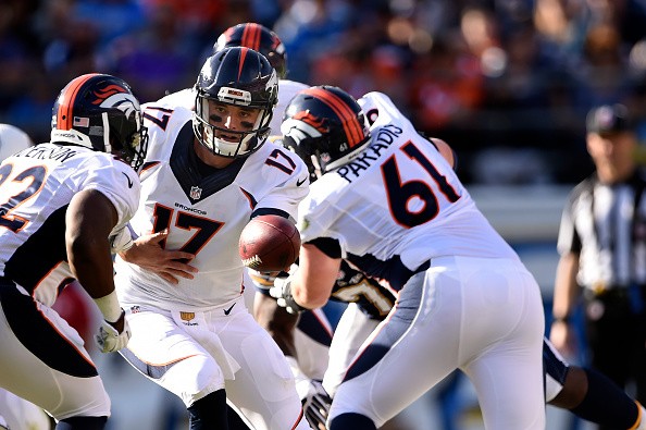 Quarterback Brock Osweiler #17 hands the ball off to C.J. Anderson #22 