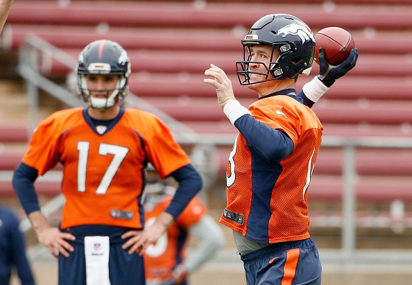 Brock Osweiler #17 watches Peyton Manning #18 of the Denver Broncos 