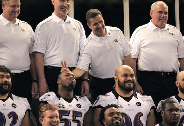 Baltimore Ravens head coach John Harbaugh jokes with outside linebacker Terrell Suggs