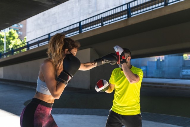 Spanish Woman Training Boxing with Coach Outdoors. .